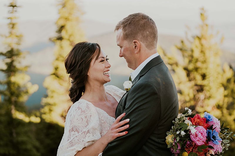 couple embracing on a mountain top in wedding attire